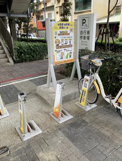 The board at a station reading 先登錄 再騎乘 - the free injury insurance notice for YouBike members.