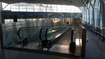 The upper-level walkway linking HSR Taichung and TRA Xinwuri stations, with moving walkways.